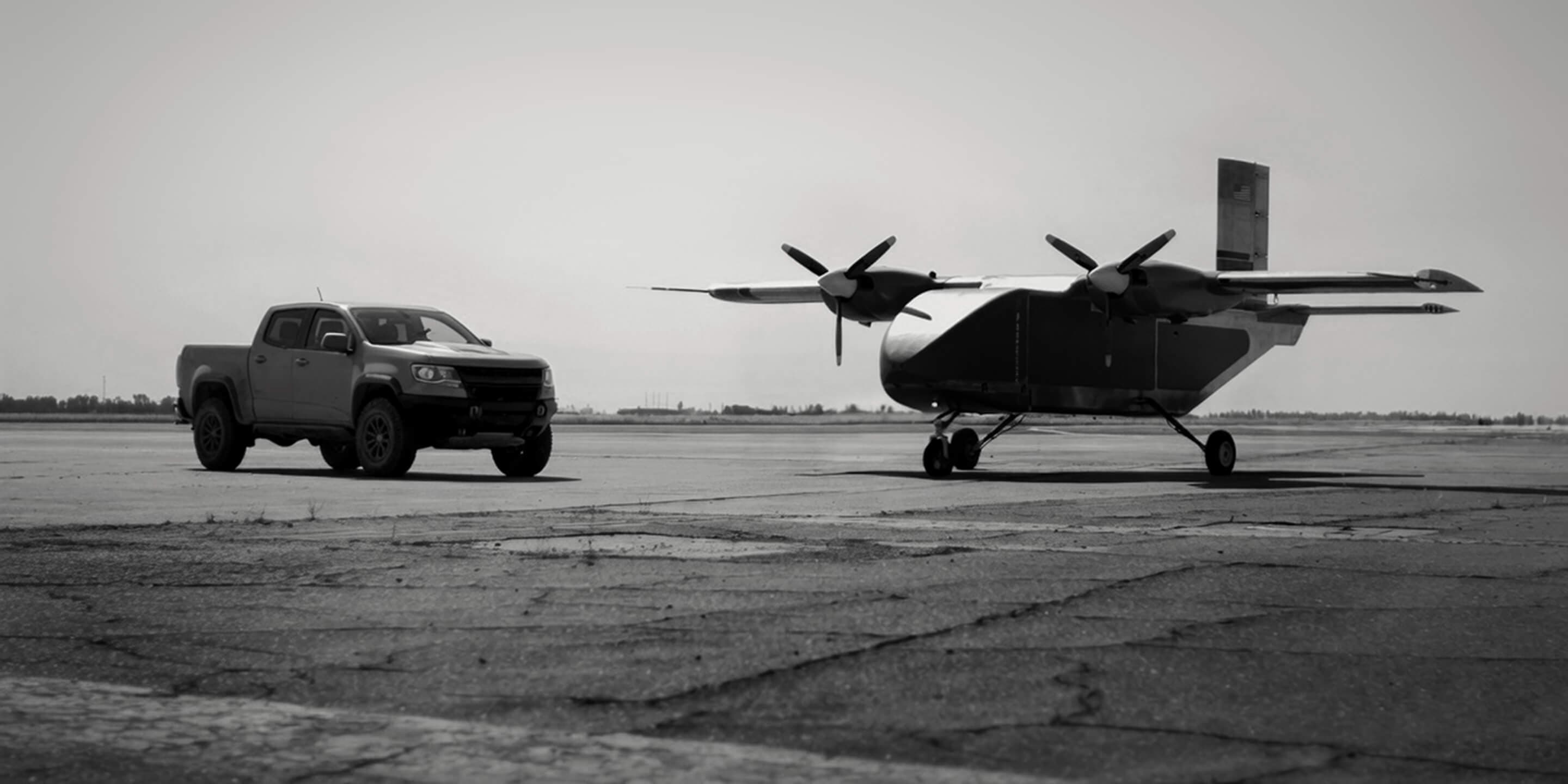 Lifter Lite aircraft alongside a pickup truck on the tarmac