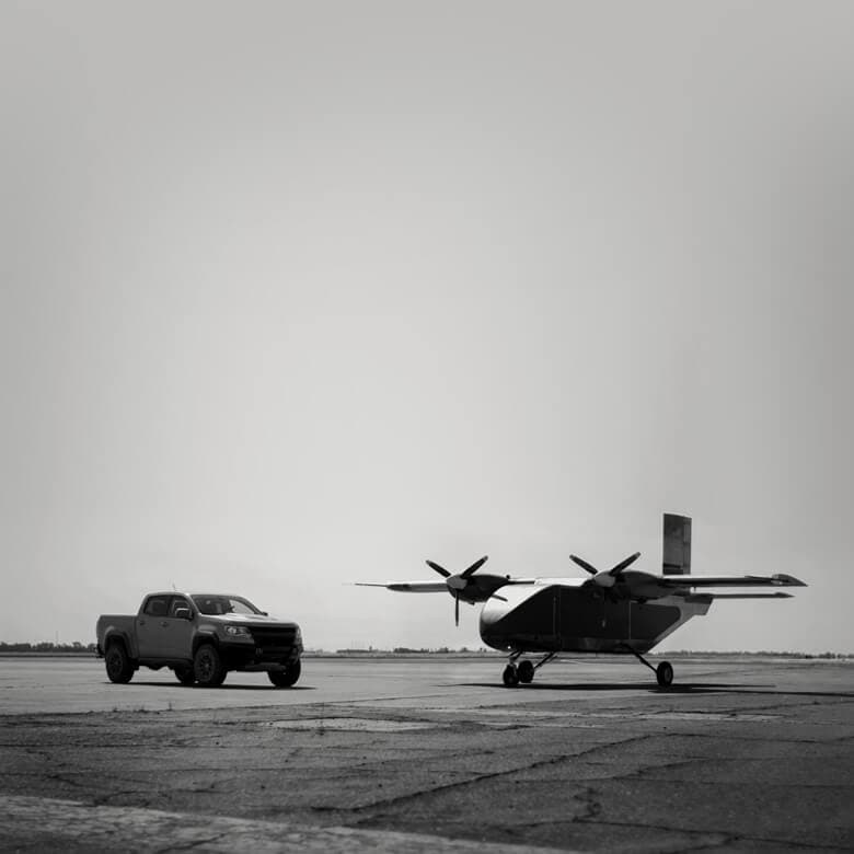 Lifter Lite aircraft alongside a pickup truck on the tarmac
